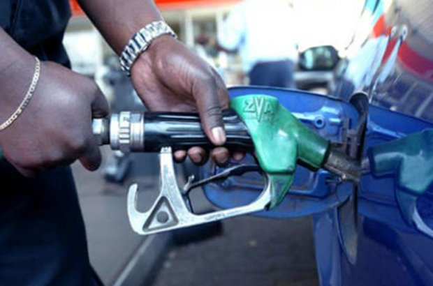 An unknown petrol station worker fueling a customers car